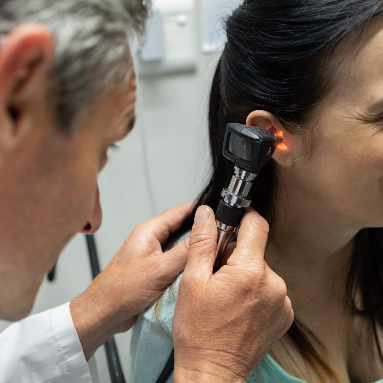Mid section of Caucasian male doctor examining a pregnant Caucasian woman in examination room of the hospital
