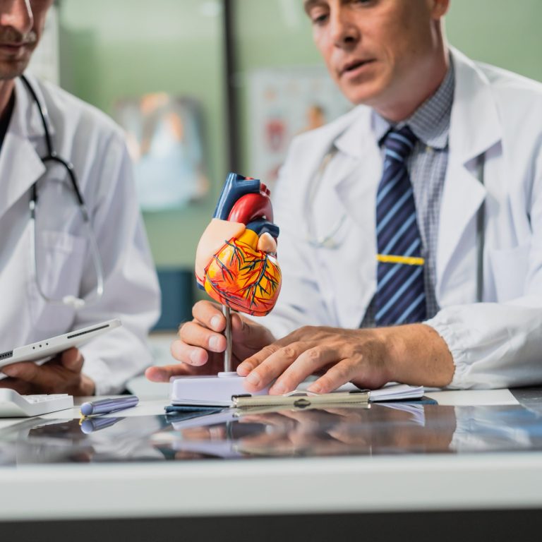 Caucasian middle-aged male doctor Italian scientific researcher are seated at desk, discussing